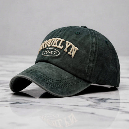 View of a casual chic embroidered cap in light gray, featuring intricate stitching and a curved brim