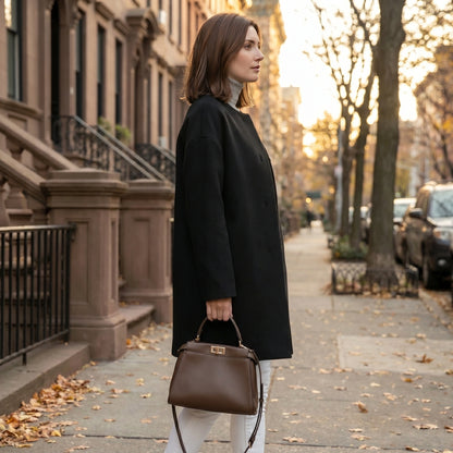Close up of the Womens Polished Minimalist Winter Coat showing the luxurious fabric texture and precise stitching, showing its sophisticated design against a neutral background.