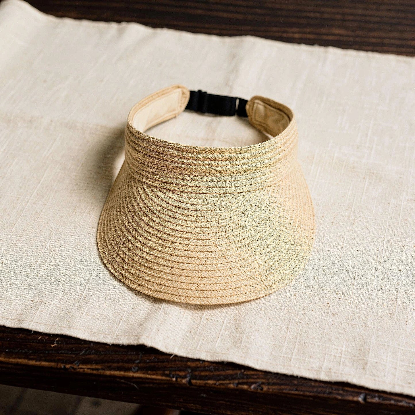 Light beige summer visor hat with a wide brim and stylish woven texture, detailed view showcasing the fabric and design