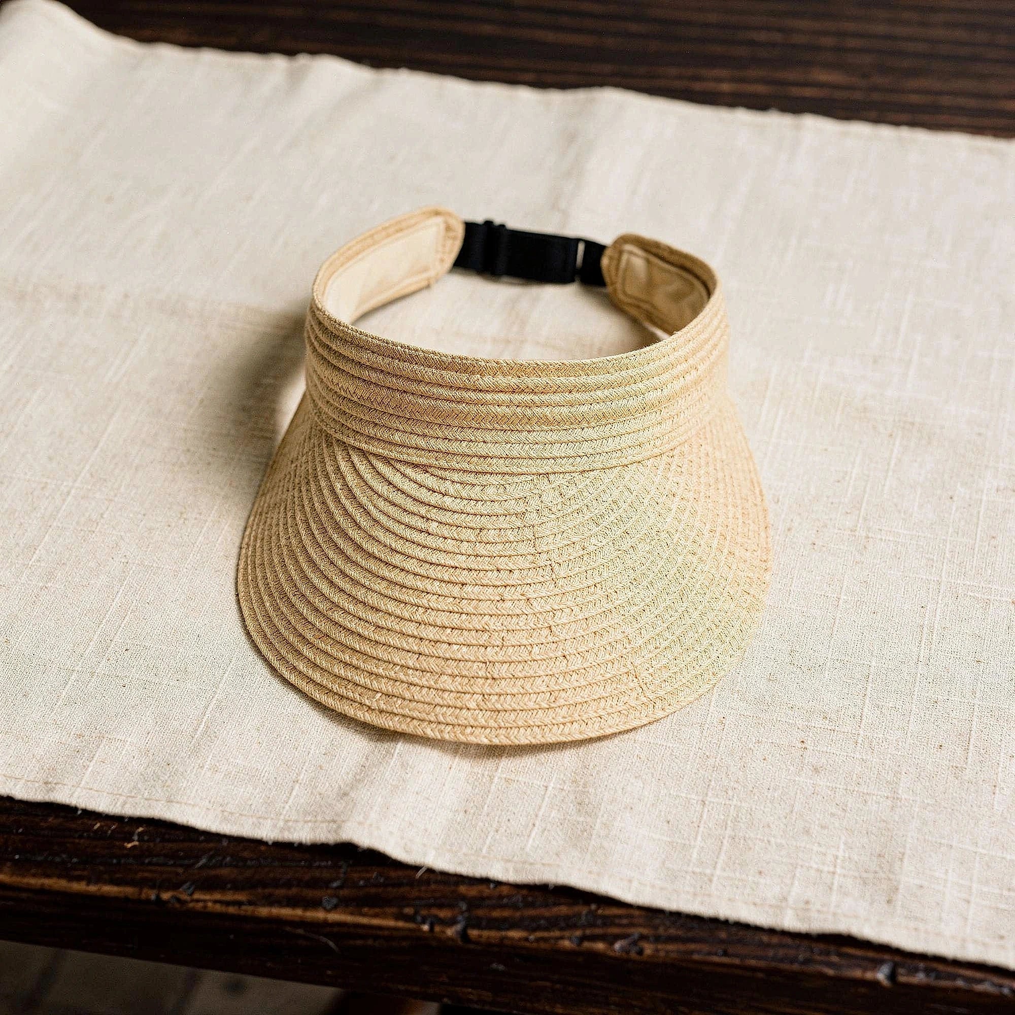 Light beige summer visor hat with a wide brim and stylish woven texture, detailed view showcasing the fabric and design