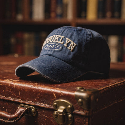 View of a navy blue embroidered cap featuring a casual chic design and adjustable strap at the