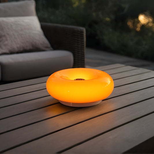 View of a sleek modern glass donut table lamp with adjustable lighting, featuring a clear glass body and a minimalist design
