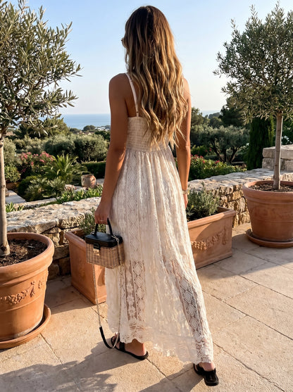 Front view of a model showing a women's flowy summer dress in soft pastel colors, styled for a beach vacation against a serene coastal background.