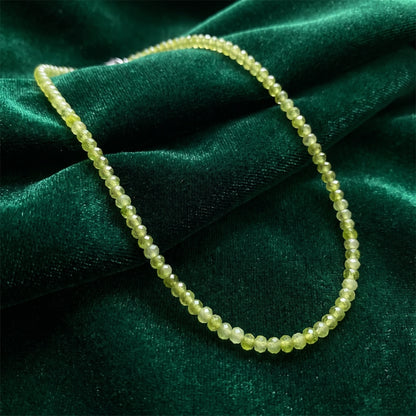 Back view of a women's classic peridot necklace showing its intricate construction details against a soft, neutral background, showing its sophisticated design.
