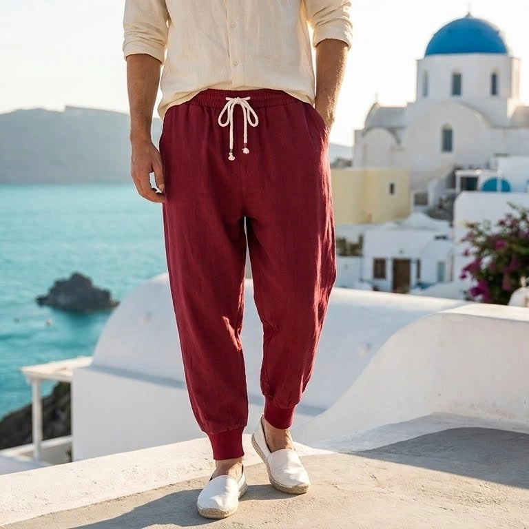 Back view of a model wearing men's relaxed summer linen pants in a light beige hue, showing the construction details against a neutral background.