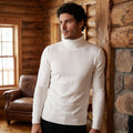 A model showcases a mens fitted turtleneck sweater in a rich navy color, styled with tailored trousers against a neutral backdrop.
