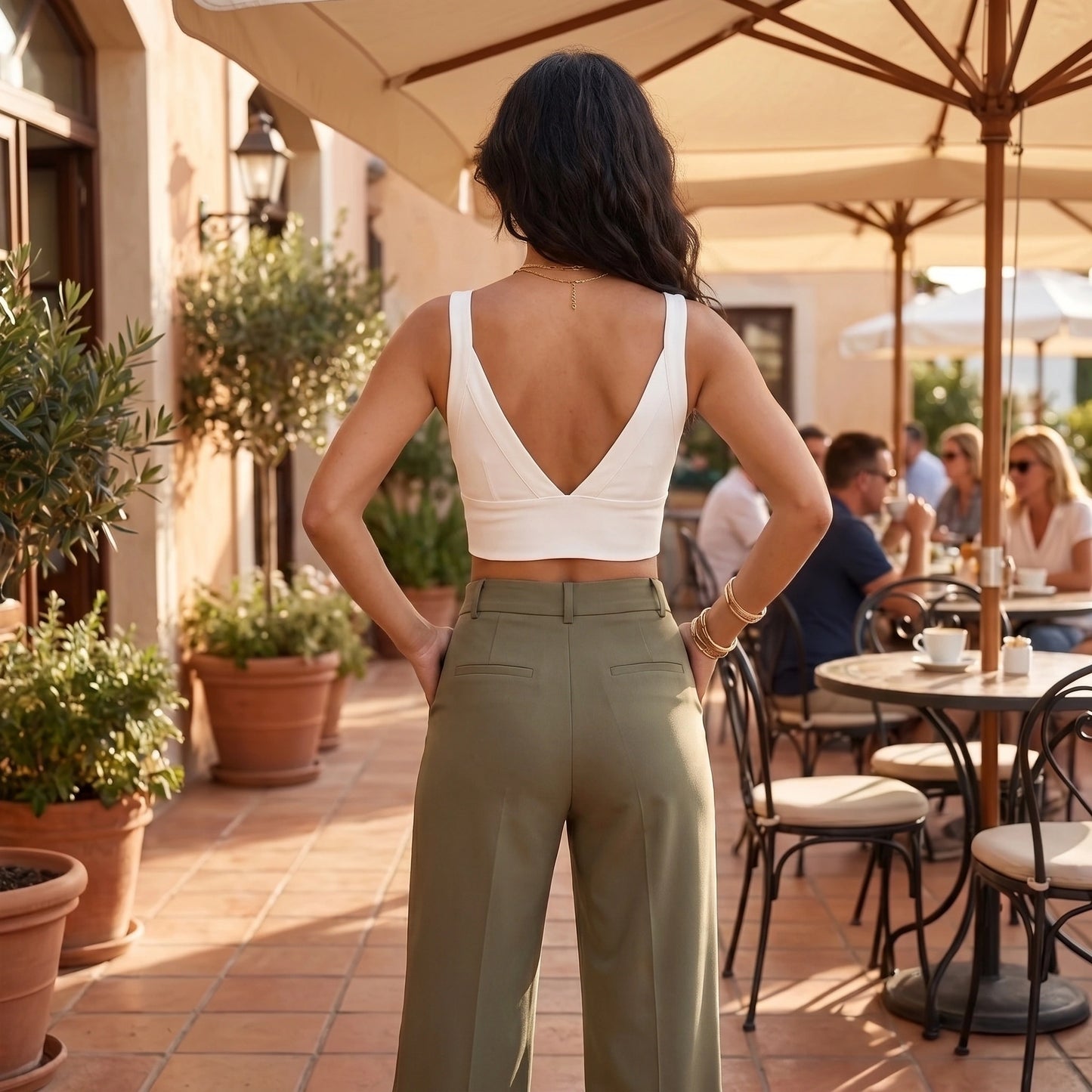 Back view of a model showing the Womens Supportive Cropped Top in a soft charcoal color, showing its construction and design against a neutral background.