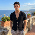 A model showcases a mens lightweight breathable summer cardigan in a soft beige color, styled with high waisted trousers against a neutral background.