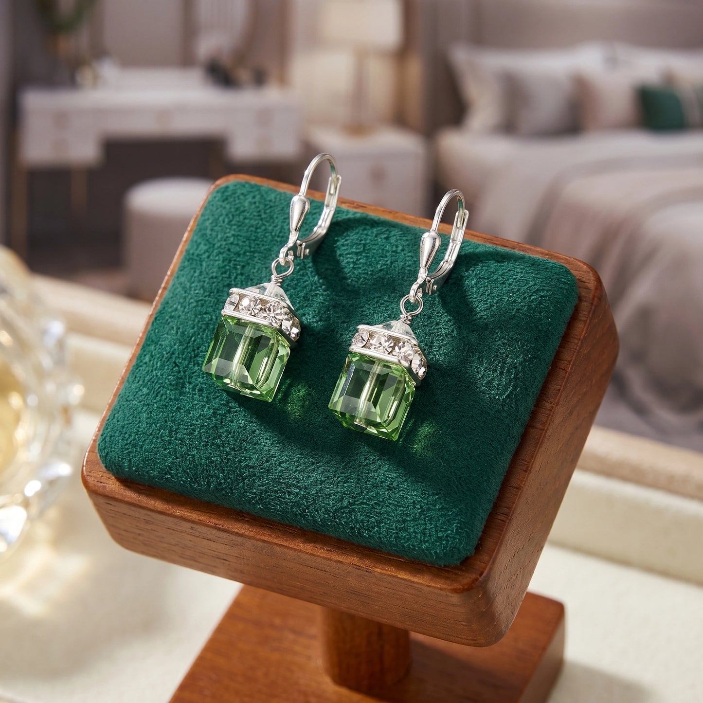 Close up of the Womens Drop Peridot Earrings showing intricate craftsmanship, vibrant green peridot stones, and a polished silver finish against a soft, neutral background.