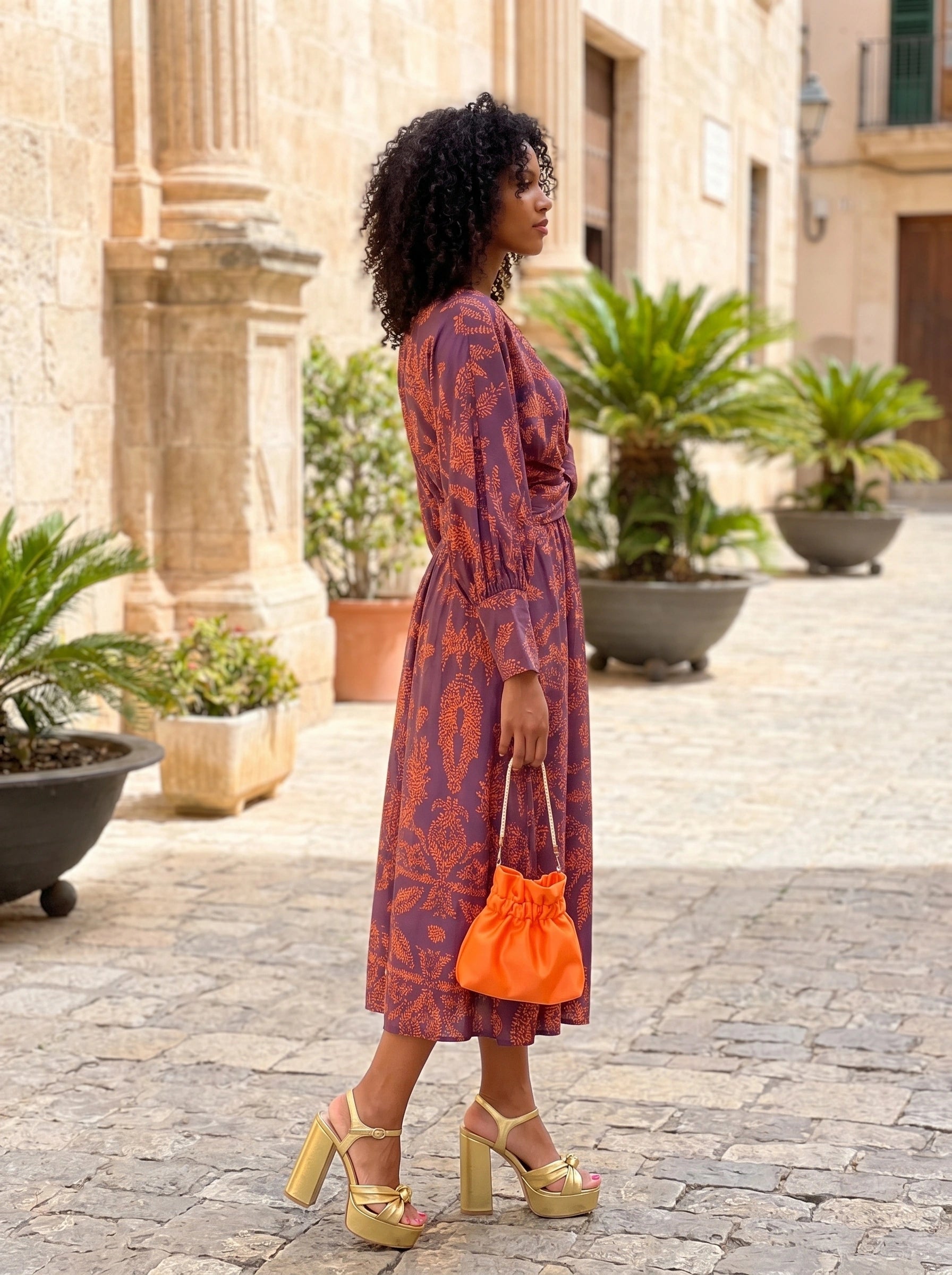 Back view of a model wearing a womens flowy summer maxi dress in soft pastel colors, showing the intricate construction details and graceful silhouette against a neutral background.