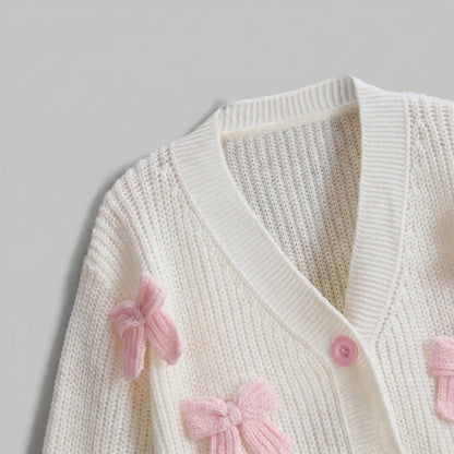 Back view of the Womens Whimsical Cozy Spring Cardigan in soft pastel colors, showing its intricate stitching and relaxed fit against a light, neutral background.