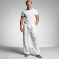 View of relaxed fit drawstring pants in light gray fabric, featuring an elastic waistband and pockets