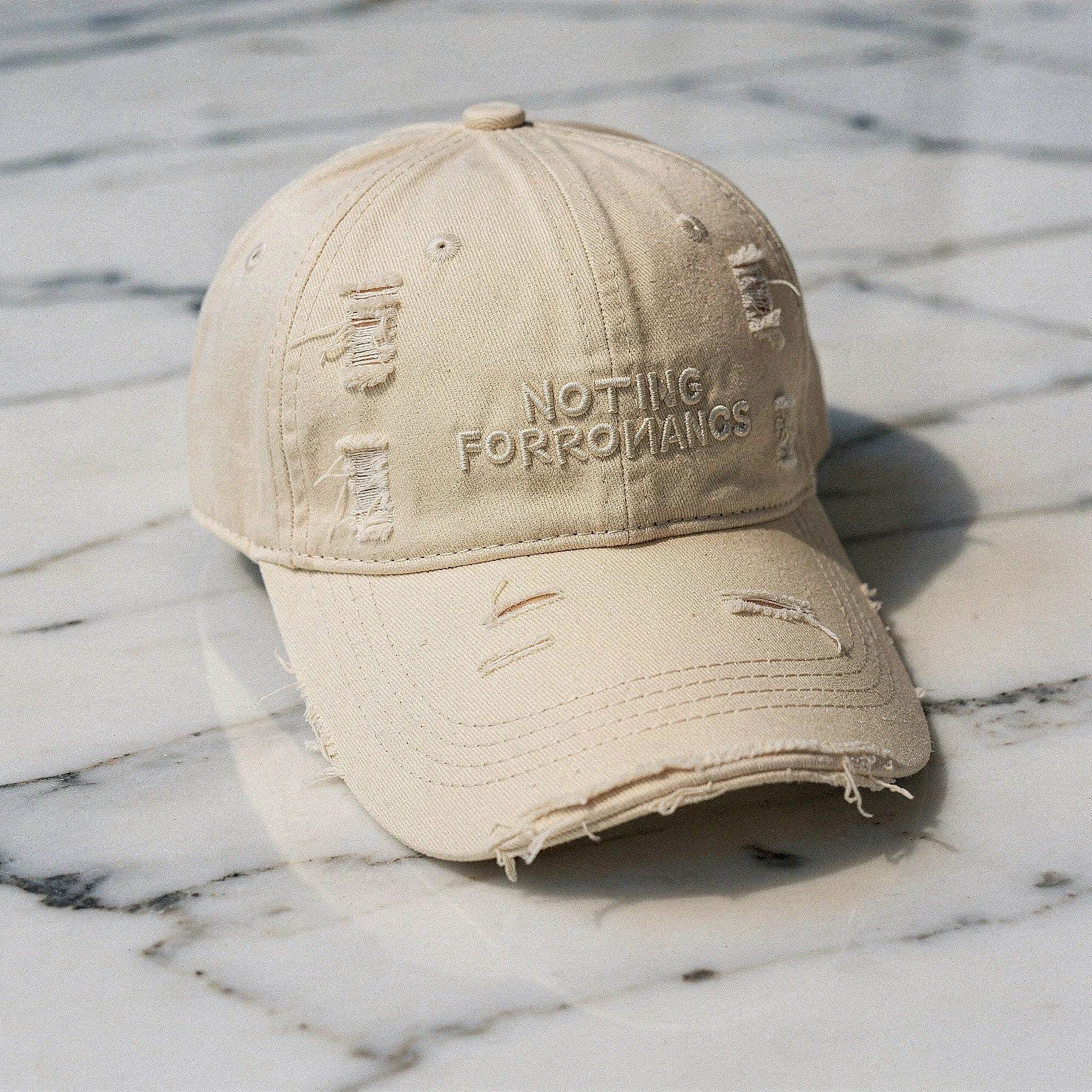 View of a chic distressed baseball cap in light blue denim, featuring a curved brim and adjustable strap
