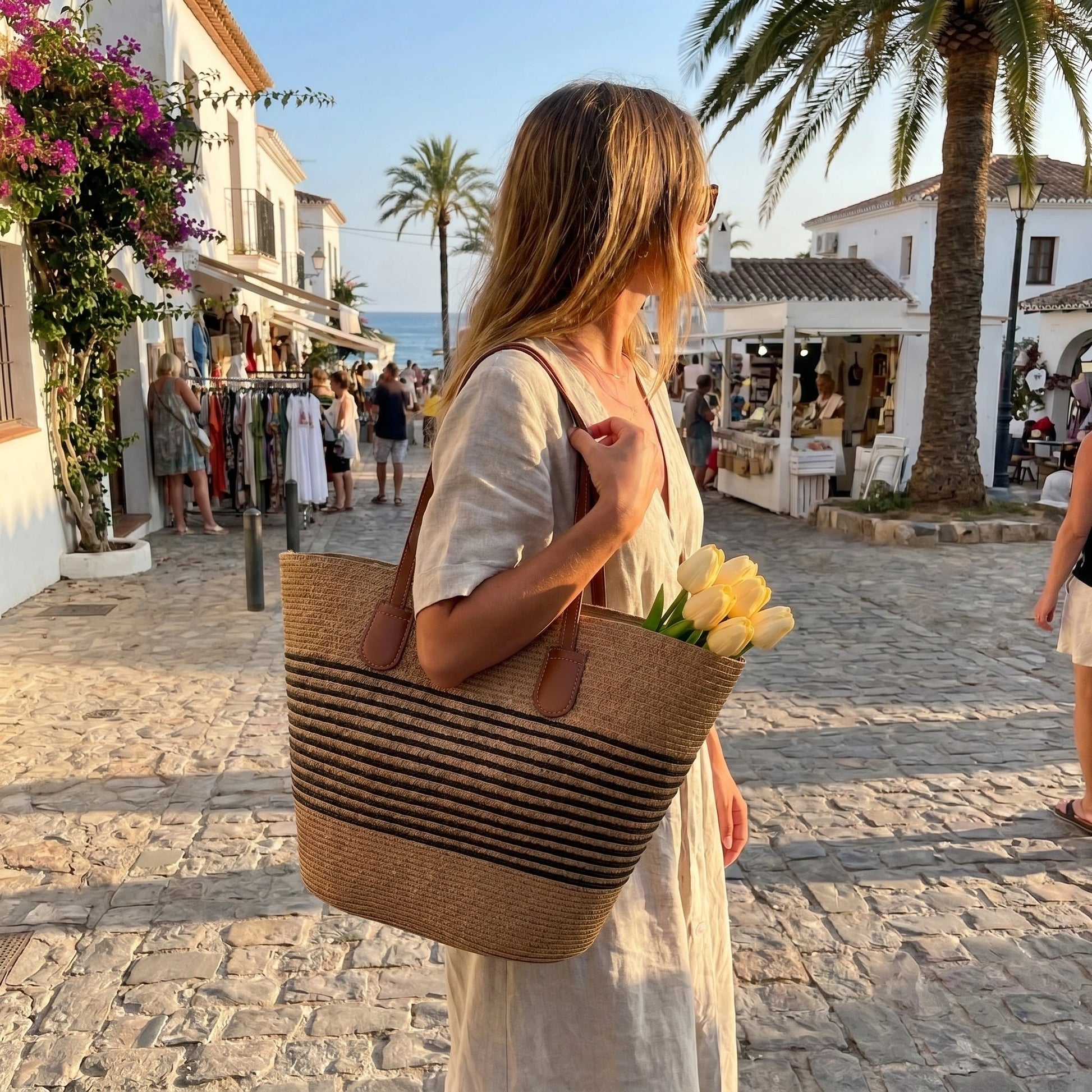 Back view of a women's spacious summer shoulder bag showing its design and sturdy construction, set against a bright outdoor background.
