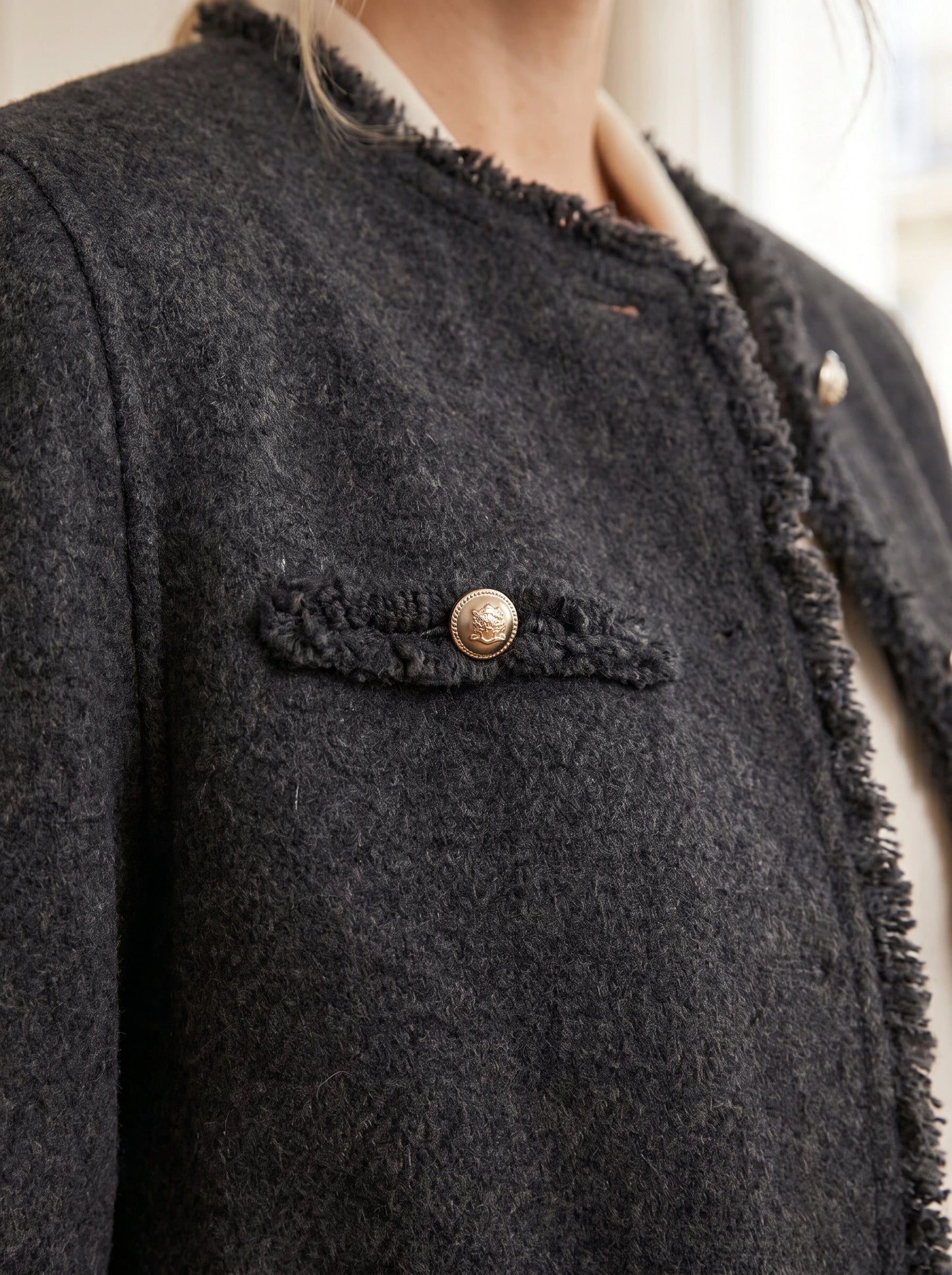 Close up of the Womens Tailored Autumn Jacket showing frayed edges, intricate stitching, and luxurious fabric texture against a soft neutral background.