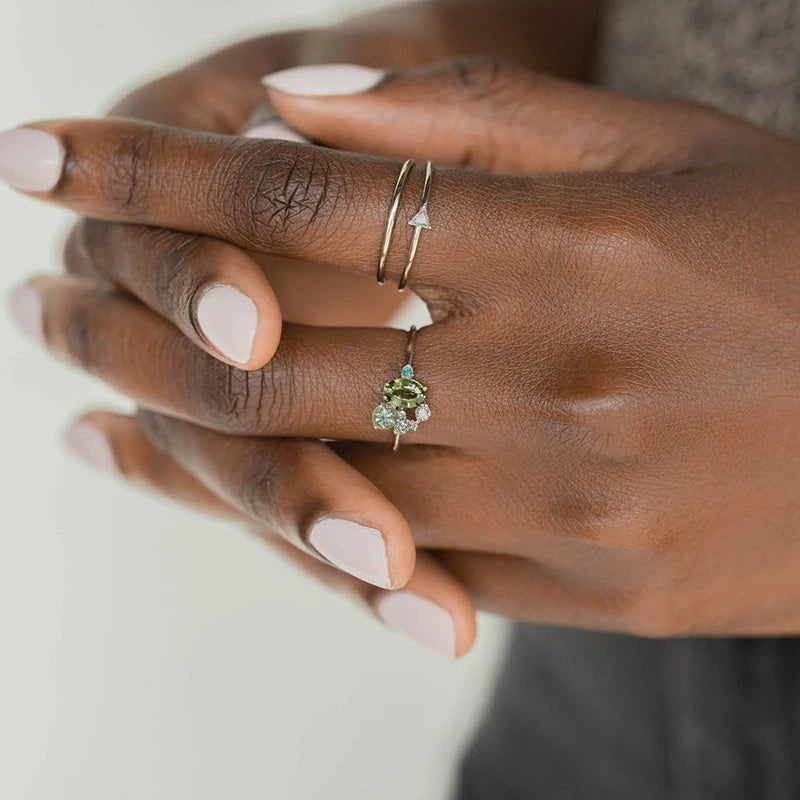 View of an elegant women's ring featuring a delicate design with a central peridot stone set in silver
