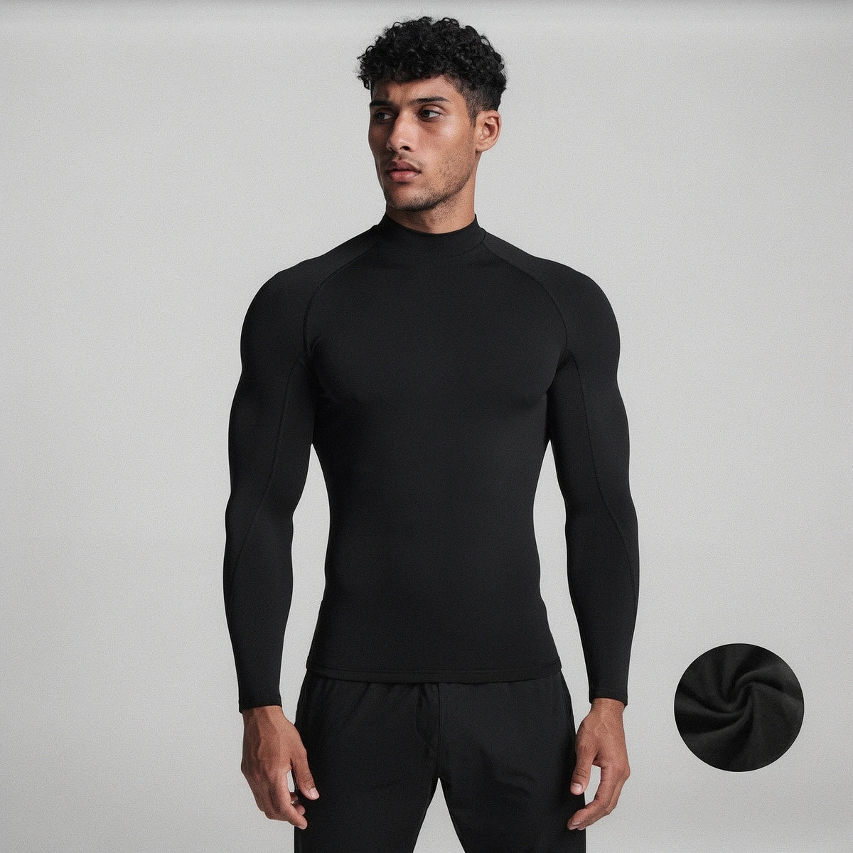 View of a black fleece backed compression winter tee with long sleeves and a fitted design