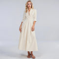 View of a flowing midi dress in soft fabric, featuring a button and a relaxed fit in a light pastel color