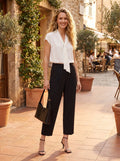 Back view of a model wearing women's tailored four way stretch cropped pants in a neutral color, showing the construction details and sleek fit against a minimalist background.
