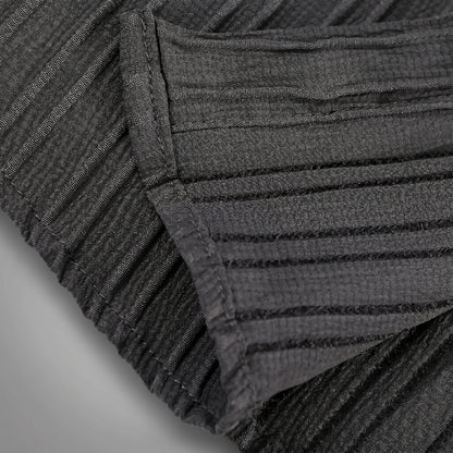 Close up view of the mens textured relaxed spring shirt showing intricate fabric details and stitching in a soft pastel color against a neutral background.