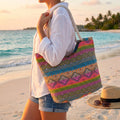 Back view of a Women's Versatile Summer Handbag showing its construction details, showing a design in a soft beige color against a light beach backdrop.
