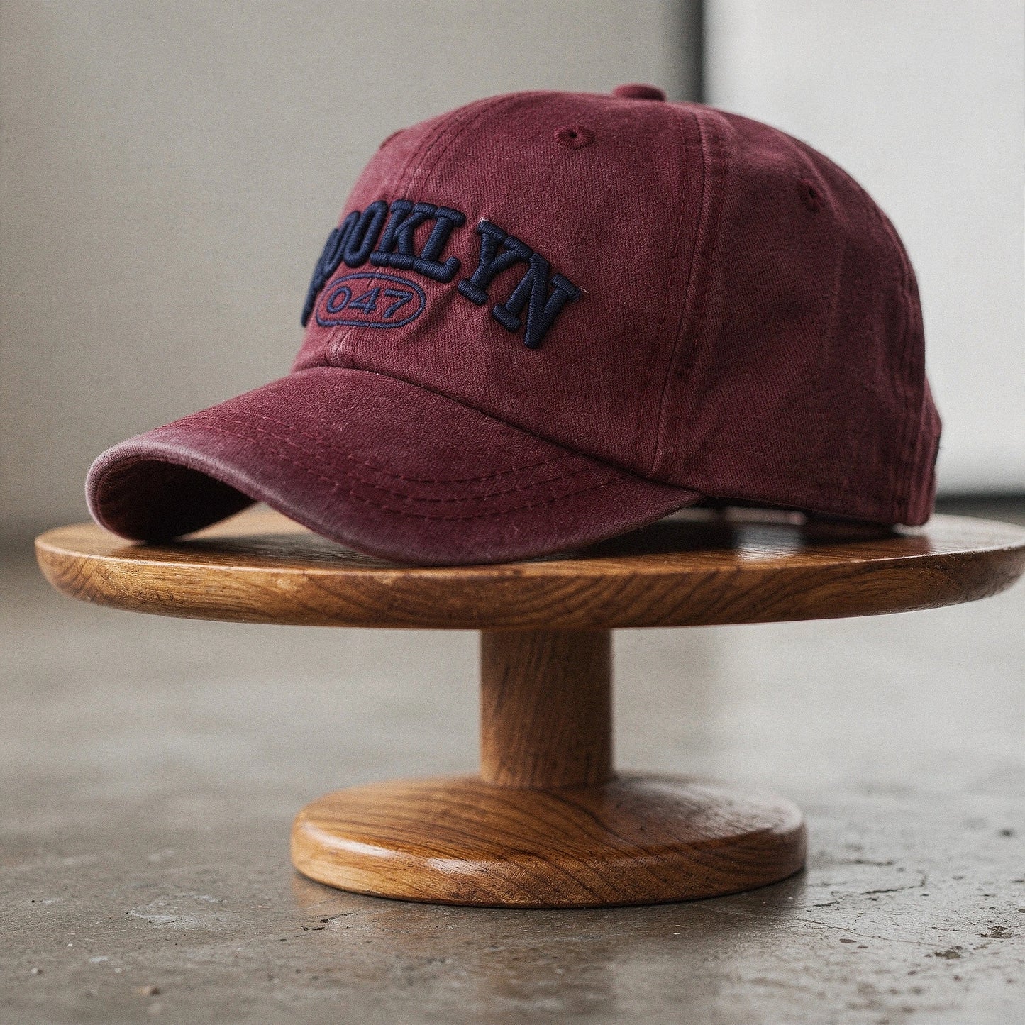 View of a light gray embroidered cap featuring a curved brim and adjustable strap at the