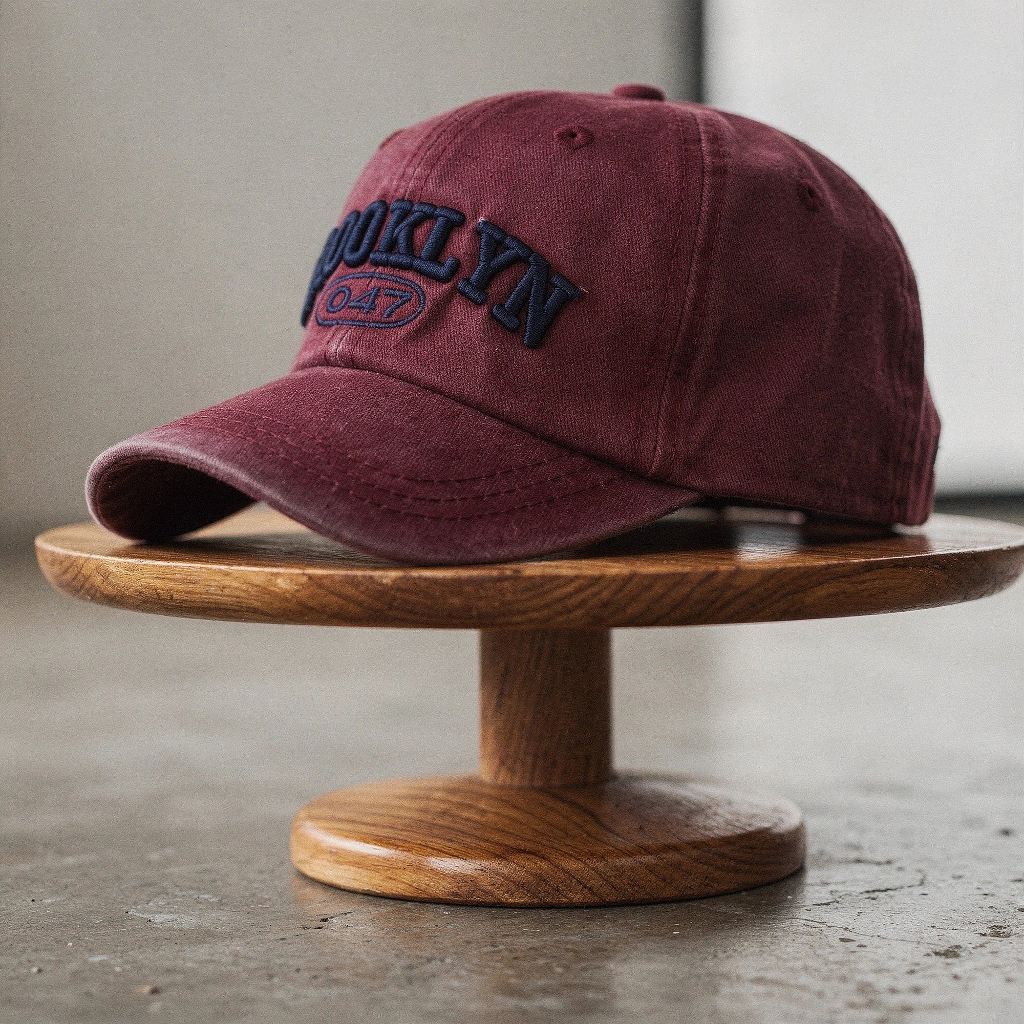 View of a light gray embroidered cap featuring a curved brim and adjustable strap at the