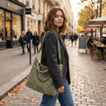 Back view of a model showing the Womens Versatile Handbag in a sleek black design, showing its construction details against a minimalist background.