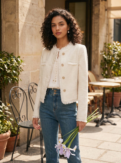 Front view of a model showing a women's textured spring crop jacket in a soft pastel color, styled with high waisted trousers against a neutral background.