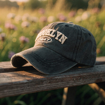 View of a navy blue cap featuring intricate white embroidery, showcasing a casual chic design and soft fabric