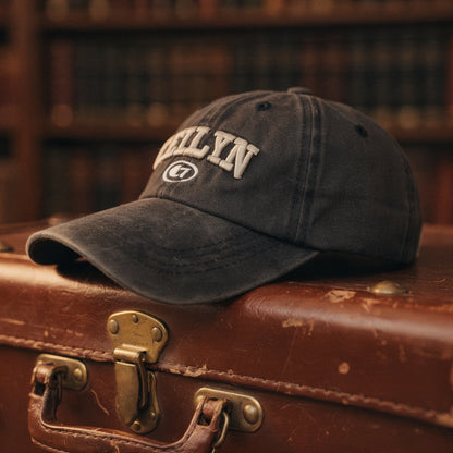View of a navy blue embroidered cap featuring a casual chic design and adjustable strap at the