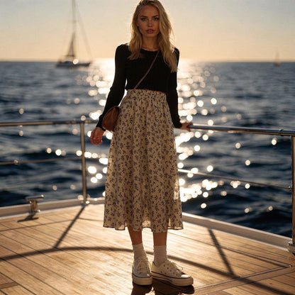 Light pink midi skirt made of flowy fabric, featuring a tiered design and delicate floral patterns, view