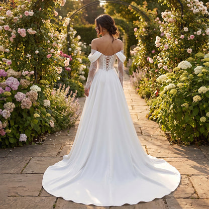 Close up view of the ivory fabric of the women's understated wedding dress, showing intricate stitching and a refined, modern design.