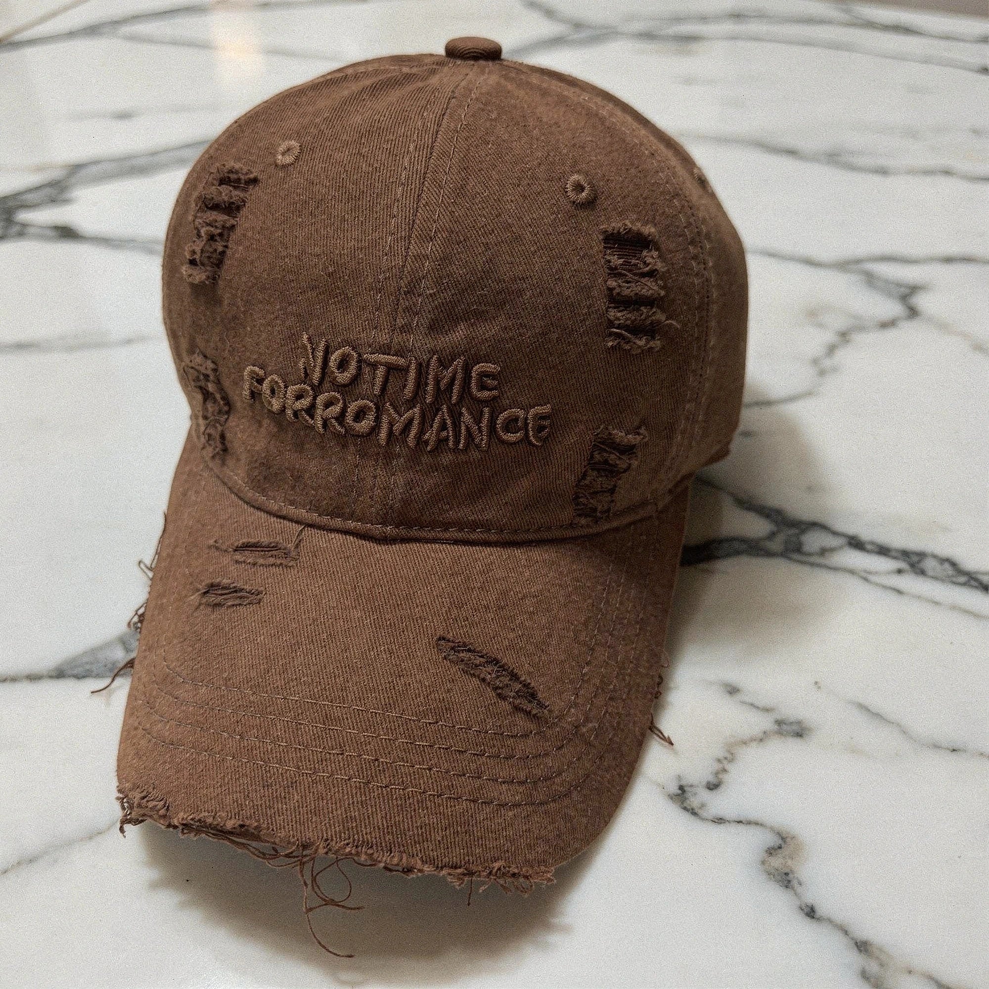 Distressed light blue baseball cap with a curved brim, adjustable strap, and subtle frayed details, angled view