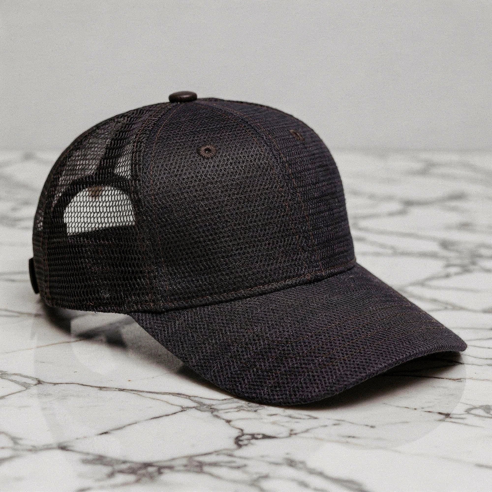 Relaxed vintage snapback cap in dark gray with a textured fabric and adjustable strap, detailed view highlighting stitching and design