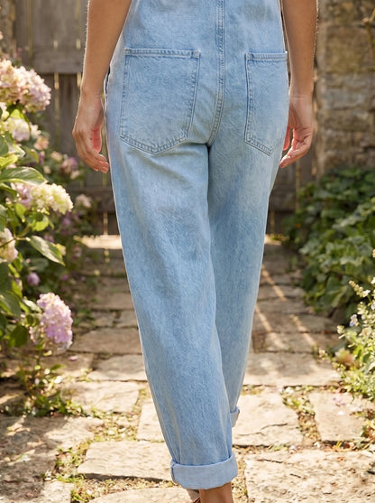 Close up of the women's effortless vintage inspired denim overalls showing the soft blue fabric, detailed stitching, and relaxed fit, perfect for casual styling.