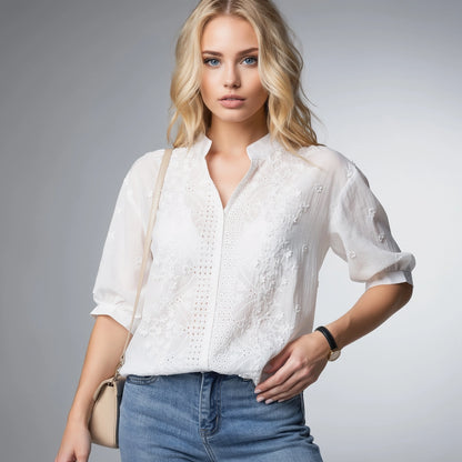 View of a light beige blouse featuring a V neckline, puff sleeves, and delicate fabric texture
