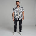 View of a slim fit short sleeve Hawaiian shirt featuring a vibrant floral print in shades of blue and green