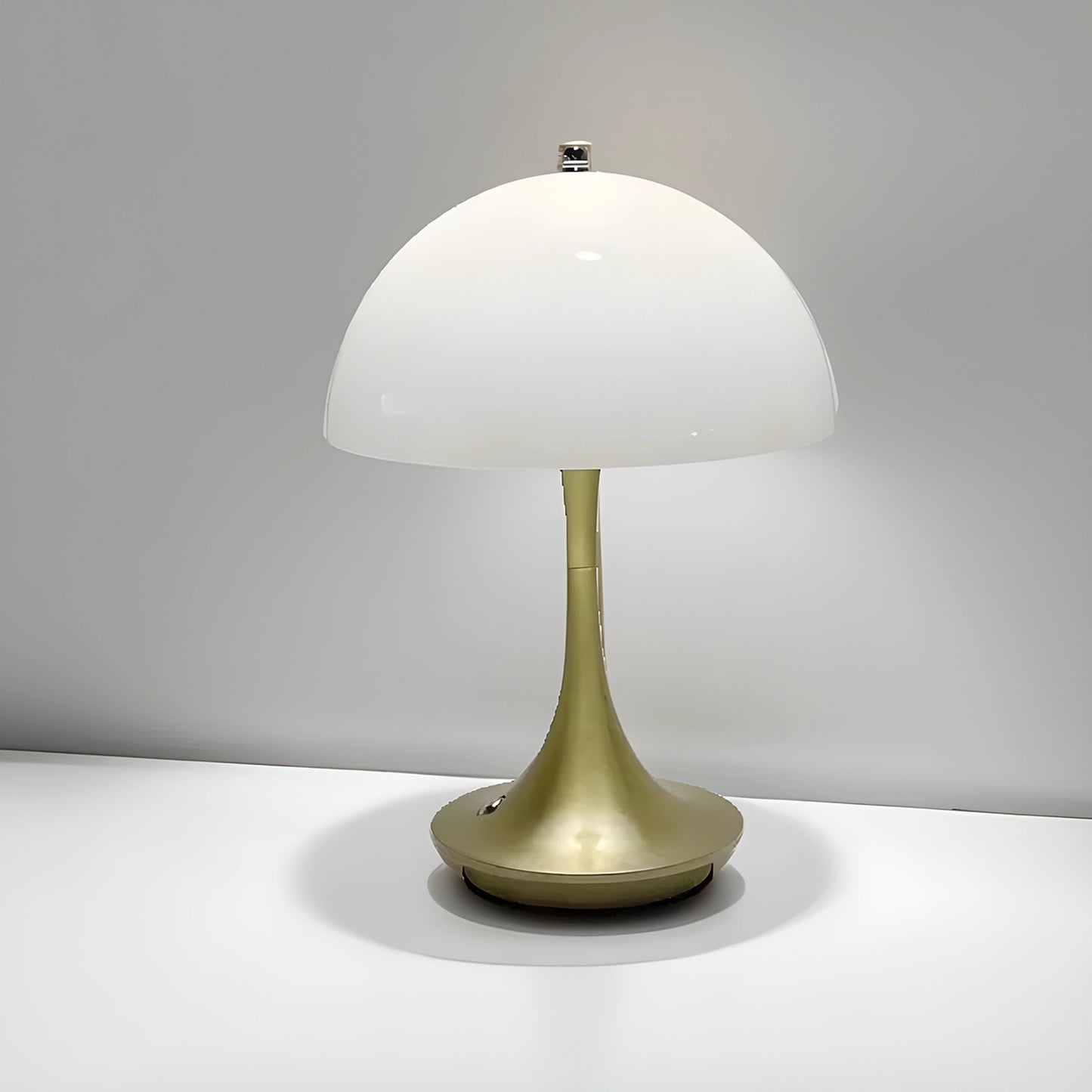 View of a sleek contemporary rechargeable table lamp in a warm brass finish, featuring a minimalist design and a soft white shade