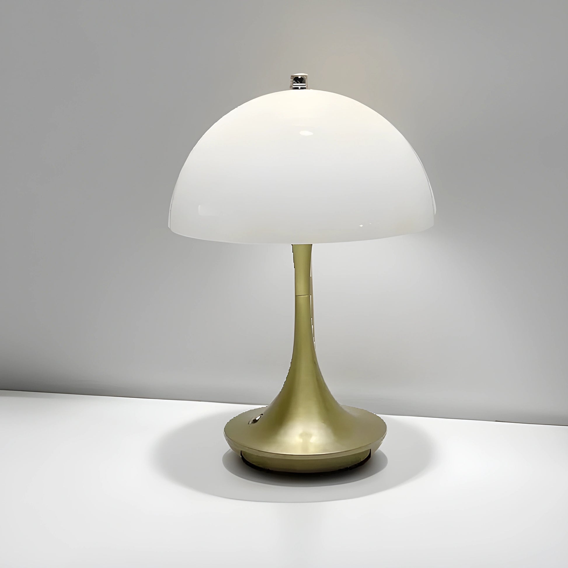 View of a sleek contemporary rechargeable table lamp in a warm brass finish, featuring a minimalist design and a soft white shade