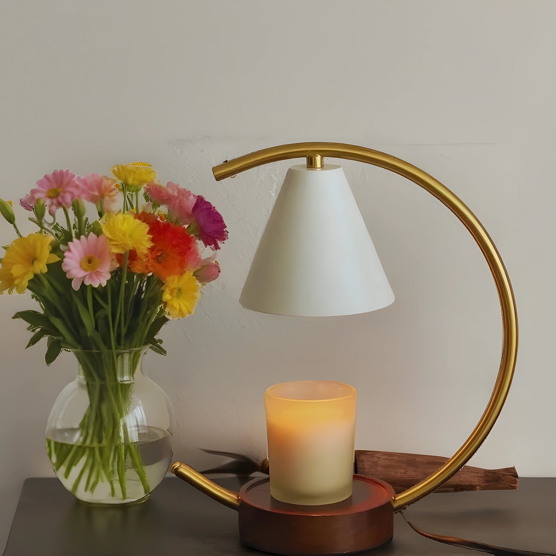 View of a sculptural dimmable candle warmer table lamp featuring a textured ceramic base in earthy tones and a soft, warm light
