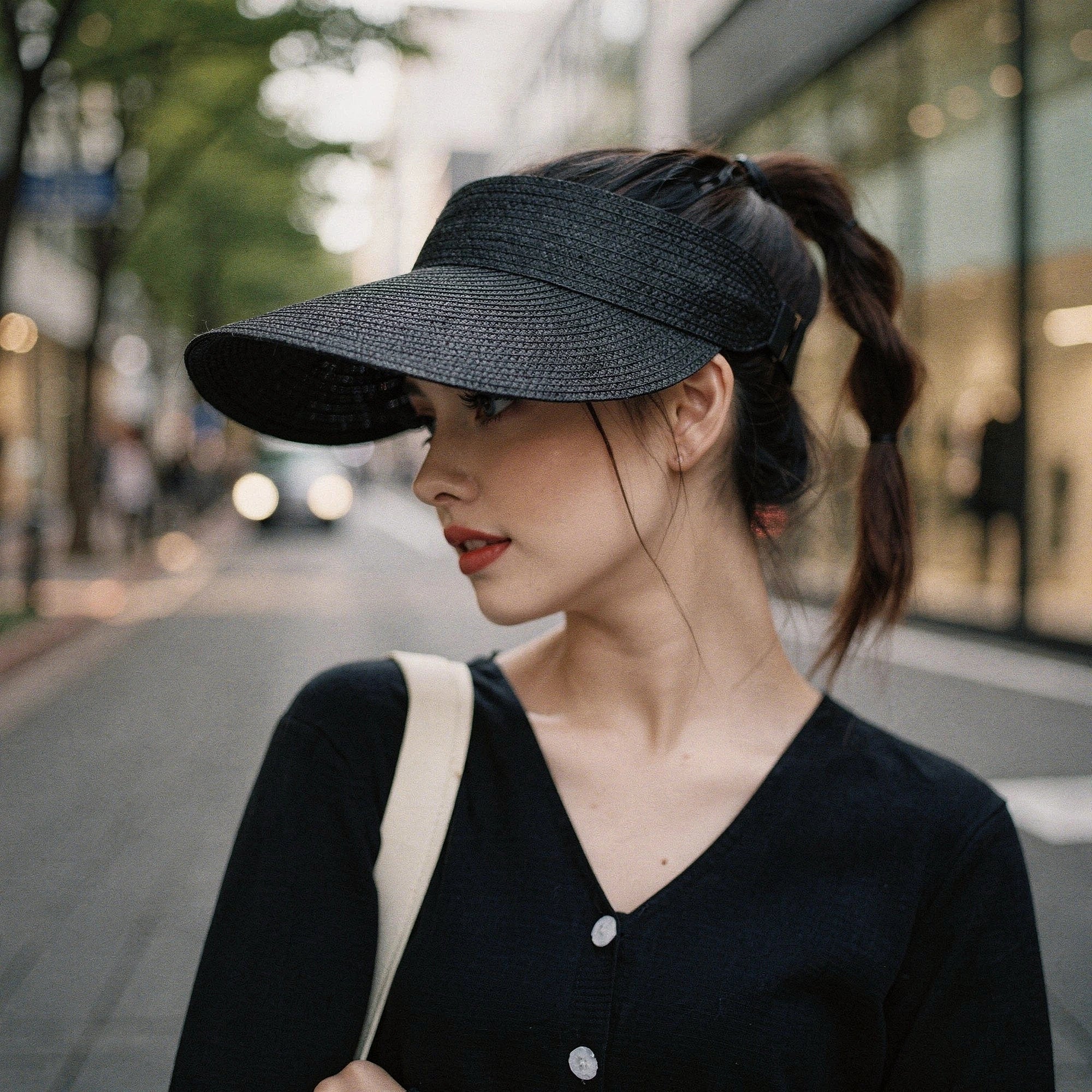 Light beige summer visor hat made of woven straw, featuring a wide brim and decorative bow , view