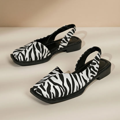 Back view of a model wearing Womens Retro Flat Sandals, showing the construction details against a soft, neutral background.