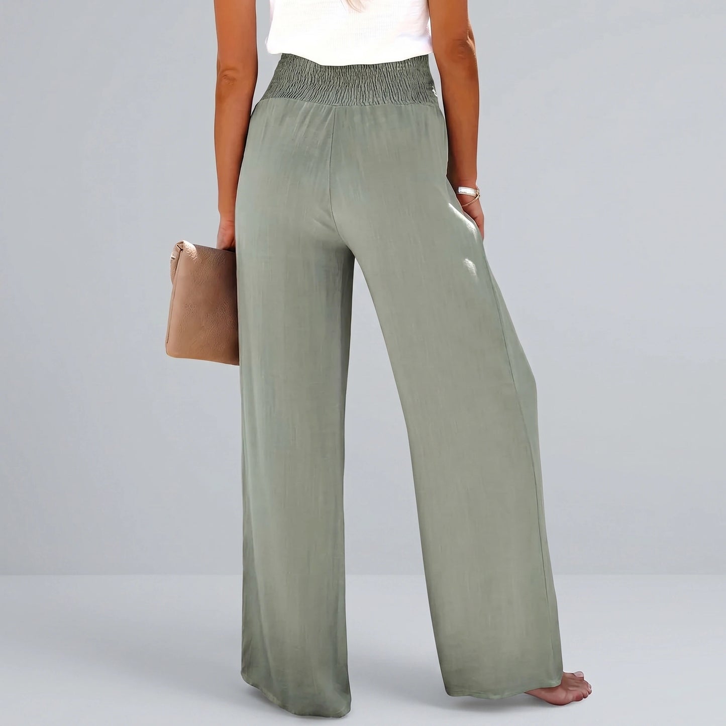 Back view of a model wearing high waisted Womens Effortless Summer Trousers in KF046 color, showing the tailored construction and flowy fabric against a neutral background.