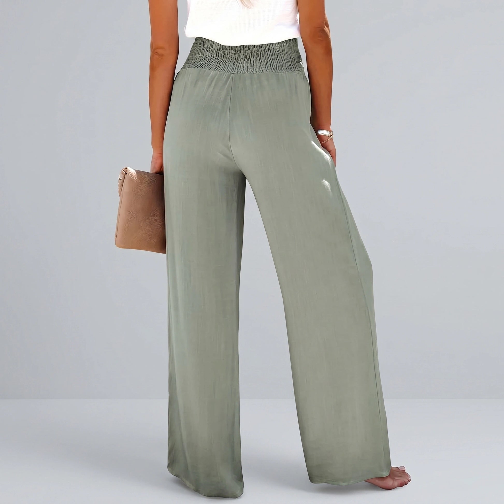 Back view of a model wearing high waisted Womens Effortless Summer Trousers in KF046 color, showing the tailored construction and flowy fabric against a neutral background.