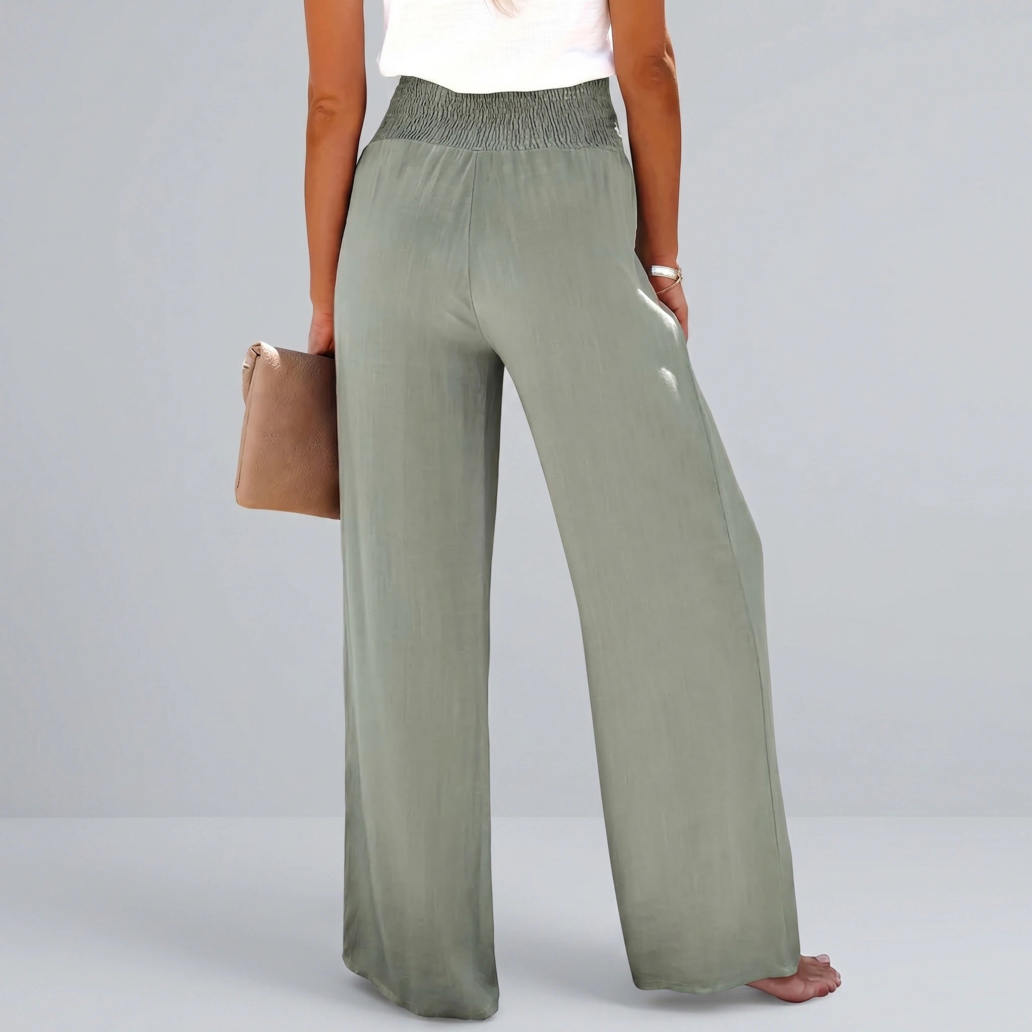 Back view of a model wearing high waisted Womens Effortless Summer Trousers in KF046 color, showing the tailored construction and flowy fabric against a neutral background.
