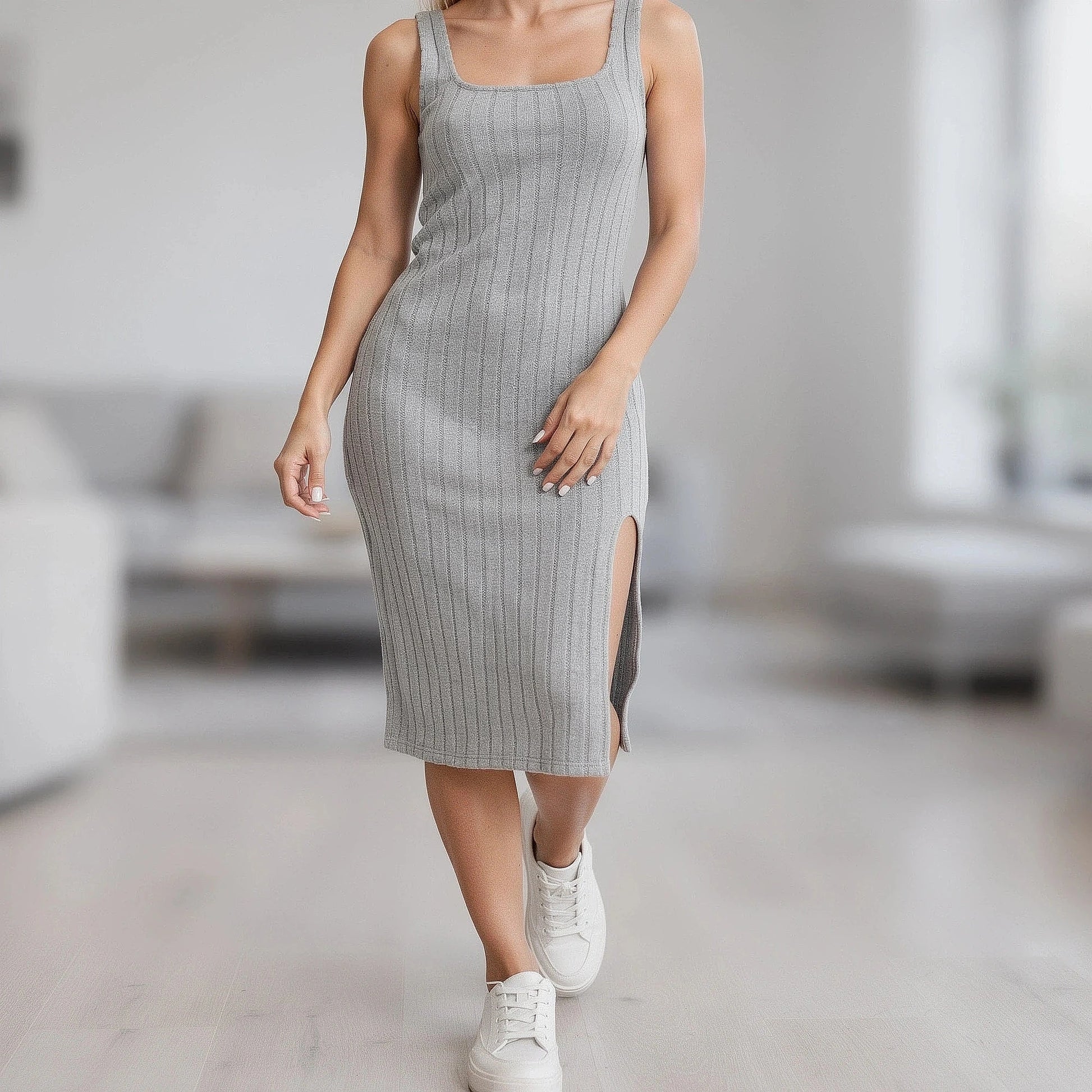 View of a relaxed knitted midi dress in soft beige, featuring a slit and a comfortable fit