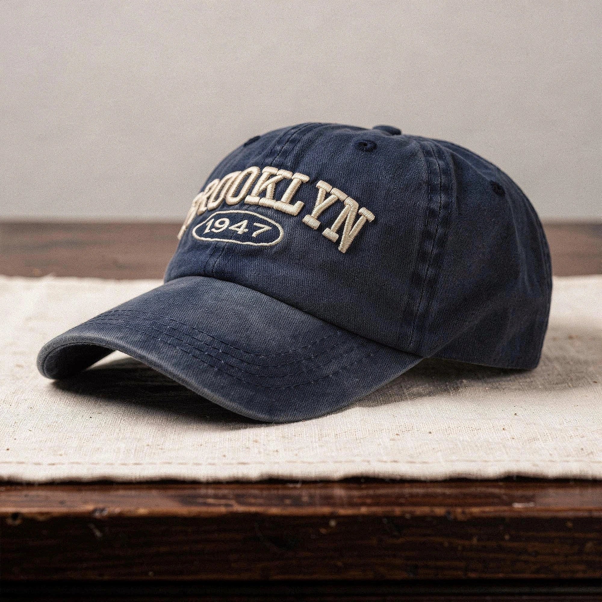 View of a navy blue cap featuring intricate white embroidery, made from soft cotton, showcasing a casual chic style
