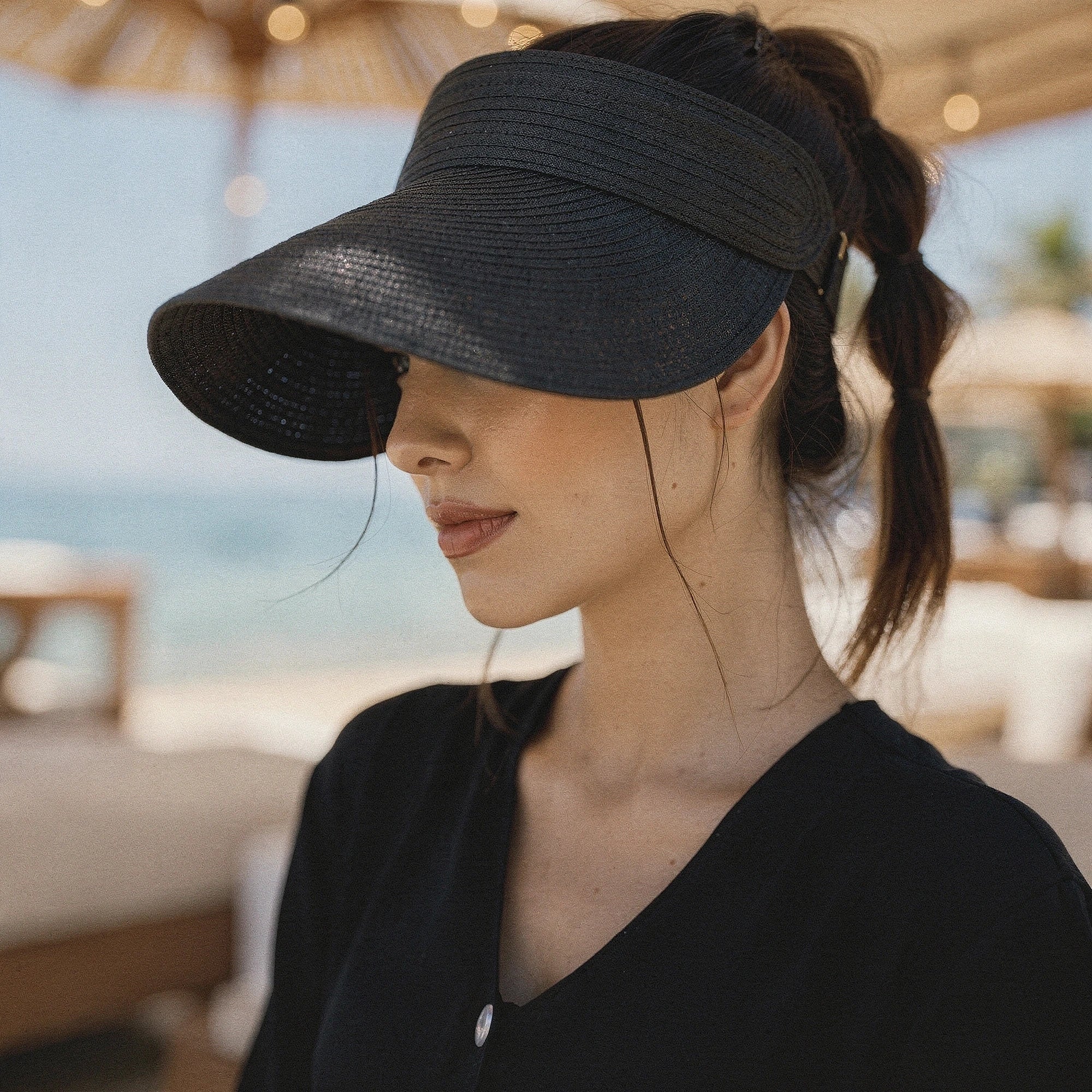 Lightweight straw summer visor hat in beige with a wide brim and a stylish black ribbon , view
