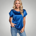 View of an elegant relaxed satin blouse in soft cream, featuring a loose fit and subtle sheen